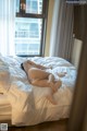 A woman laying on a bed in a hotel room.