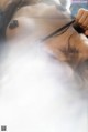 A woman laying on top of a bed covered in smoke.