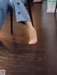 A person sitting on a chair with their feet on the floor.