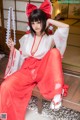 A woman in a red and white kimono sitting on a bench.