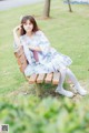 A woman sitting on a bench in a park.