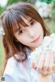 A young woman holding a bunch of white flowers.