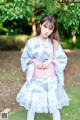 A young woman in a blue and white kimono posing for a picture.