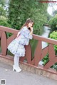 A young girl standing on a bridge next to a river.