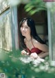 A woman in a red bikini looking out of a window.