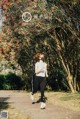 A woman wearing a face mask running in a park.