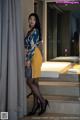 A woman standing in front of a window in a hotel room.