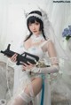 A woman in a wedding dress holding a gun.