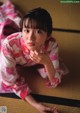 A woman in a pink and white kimono laying on the floor.