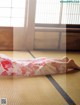 A woman laying on a tatami mat in a room.