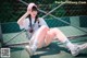 A woman sitting on a tennis court wearing a pink hat.