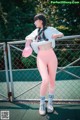 A woman in a white shirt and pink leggings standing on a tennis court.