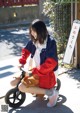 A woman sitting on a small bike on a sidewalk.