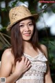 A woman in a straw hat posing for a picture.