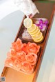 A tray of flowers and lemons on top of a bathtub.