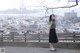 A woman standing on top of a wooden fence.