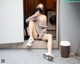 A woman wearing a face mask sitting on the steps of a house.