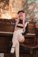 A woman with pink hair sitting on a piano.