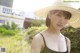 A woman wearing a straw hat standing in a field.