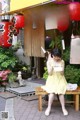 A little girl sitting on a bench in front of a restaurant.