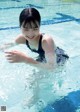 A woman in a swimming pool with her arms outstretched.