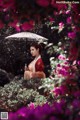 A woman in a kimono holding an umbrella in a garden.