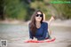 A woman laying on a surfboard in the water.