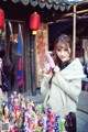 A woman standing in front of a bunch of stuffed animals.