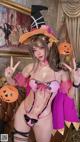 a woman in a pink lingerie and a witch hat posing for a picture