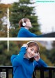 A woman in a blue sweatshirt is listening to music with headphones.