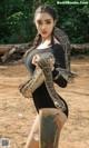 A woman holding a large snake in her hands.