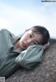 A woman laying on top of a stone wall.