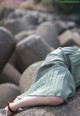 A woman laying on a rock with her legs crossed.