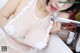 A woman in a white lingerie is washing her hands in a sink.