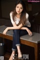 A woman sitting on top of a wooden table.