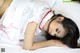 A woman laying on a bed in a white dress.