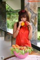 A woman in an apron holding a bowl of vegetables.