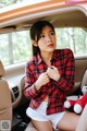 A woman sitting in the back seat of a car holding a stuffed animal.