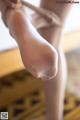 A close up of a woman's feet with a pair of white stockings.