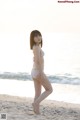 A woman in a bikini standing on a beach.