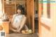 A woman sitting on the floor next to a table with a plate of food.