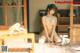 A naked asian woman sitting on a wooden floor.