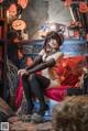 A woman sitting on a chair in a room decorated for Halloween.