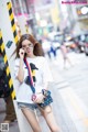 A woman in shorts and a t-shirt talking on a cell phone.