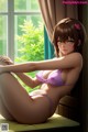 A woman in a purple bikini sitting on a window sill.