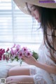 A woman in a straw hat holding a bunch of flowers.