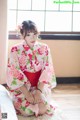 A woman in a kimono sitting on the floor.