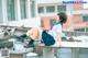 A woman in a school uniform sitting on top of a table.