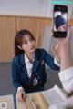 A woman taking a picture of herself in a school uniform.