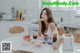 A woman sitting at a table eating a sandwich.